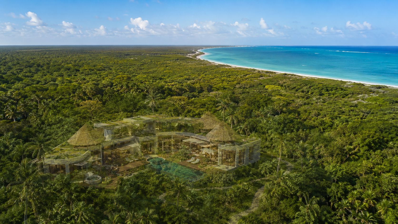 Vista aérea de una lujosa villa ecológica integrada en la selva tropical frente al mar Caribe.